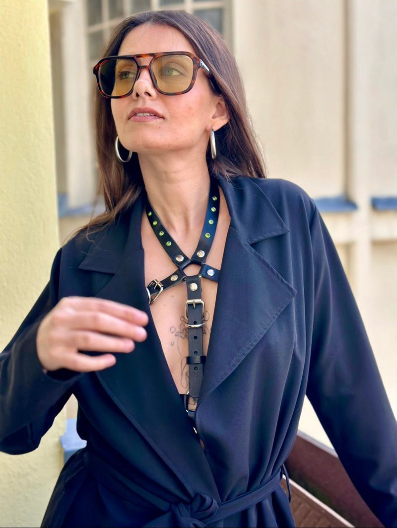 BlackTulip Leder Accessoire in Schwarz mit grünem Strass veredelt unter einem schwarzen Mantel getragen. Elegant. Nahaufnahme. - XMORENIUM-NERO