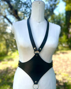 Schwarzes Lederaccessoire mit silbernen Ringen und Nieten auf Schneiderpuppe  von vorne – XMORENIUM-NERO