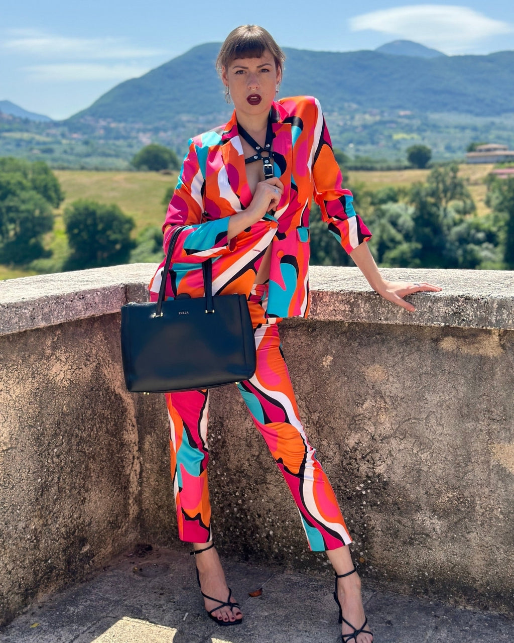 Modernes Lederaccessoire im Kontrast zum farbenfrohen Anzug – X-Morenium NERO Look