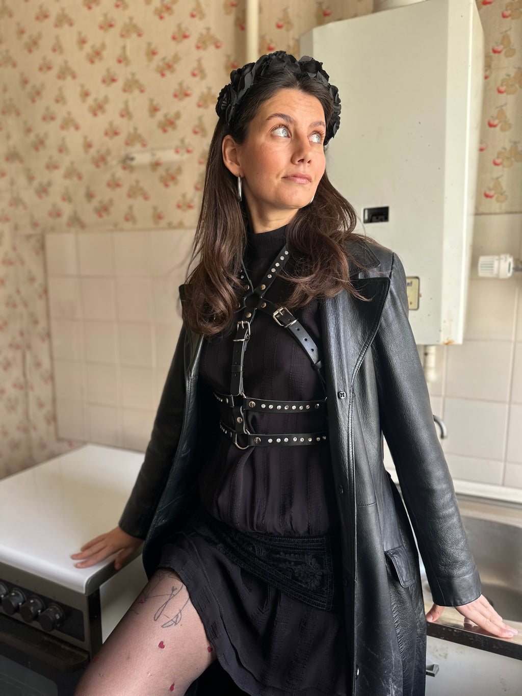 BlackTulip Leder Accessoire mit weißem Strass veredelt, über einem schwarzen Kleid und Ledermantel darüber , leicht seitliche Einstellung - XMORENIUM-NERO