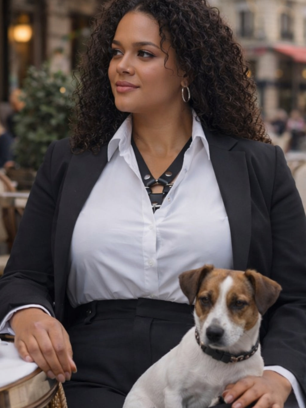 Attraktive Frau trägt BlackTulipXXL Leder Accessoire in Schwarz unter einer weißen Bluse mit schwarzem Jackett zur schwarzen Hose, sitzend mit Jack Russell Terrier – XMORENIUM-NERO