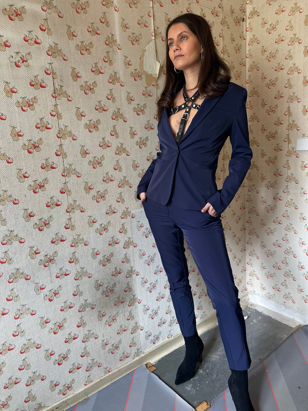 BlackTulip Leder Accessoire mit blauem Strass veredelt, getragen mit einem blauen Hosenanzug, elegant, mit Highheels, Ganzkörperaufnahme - XMORENIUM-NERO