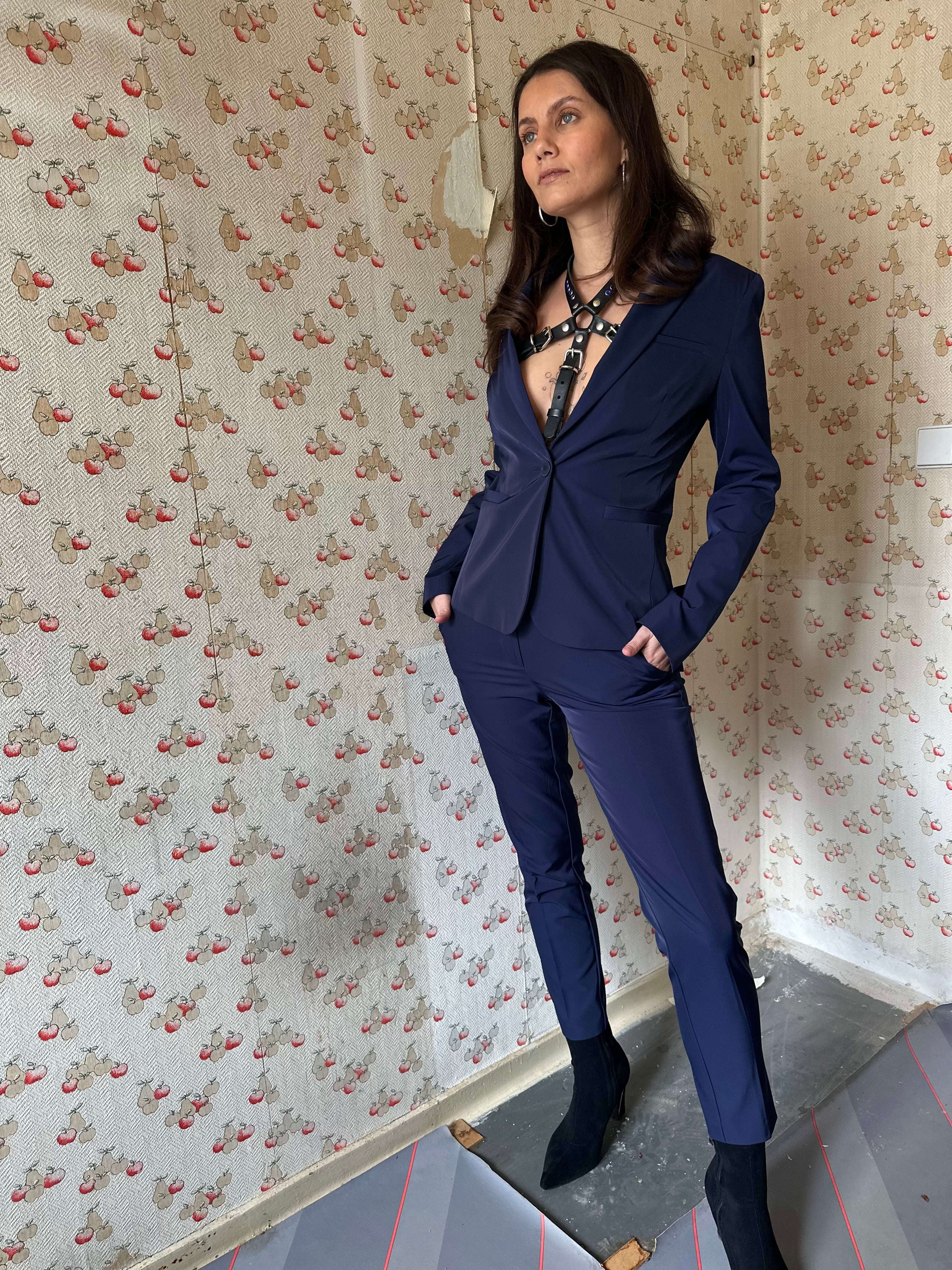 BlackTulip Leder Accessoire mit blauem Strass veredelt, getragen mit einem blauen Hosenanzug, elegant, mit Highheels, Ganzkörperaufnahme - XMORENIUM-NERO