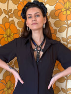 BlackTulip Leder Accessoire mit blauem Strass veredelt, getragen unter einem schwarzen Kleid, Nahaufnahme - XMORENIUM-NERO