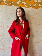 RedTulip Leder Accessoire in Rot mit Rotem Strass veredelt, auf der Haut unter einem roten Mantel. Hier blitzt der obere Teil des  RedTulip RedDiamant mit seinem Strass auf. Ganzkörperaufnahme - XMORENIUM-NERO