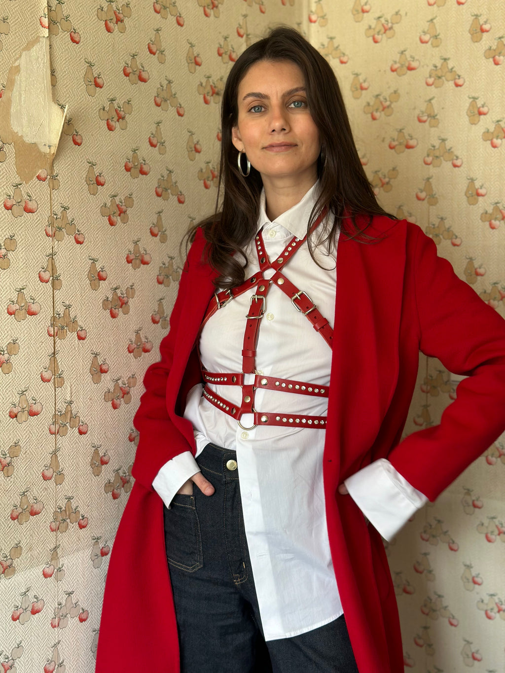 RedTulip Leder Accessoire in Rot mit weißem Strass veredelt, über weißer Bluse zur Jeans und rotem Mantel, Ganzkörperaufnahme – XMORENIUM-NERO