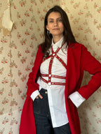 RedTulip Leder Accessoire in Rot mit weißem Strass veredelt, über weißer Bluse zur Jeans und rotem Mantel, Ganzkörperaufnahme – XMORENIUM-NERO