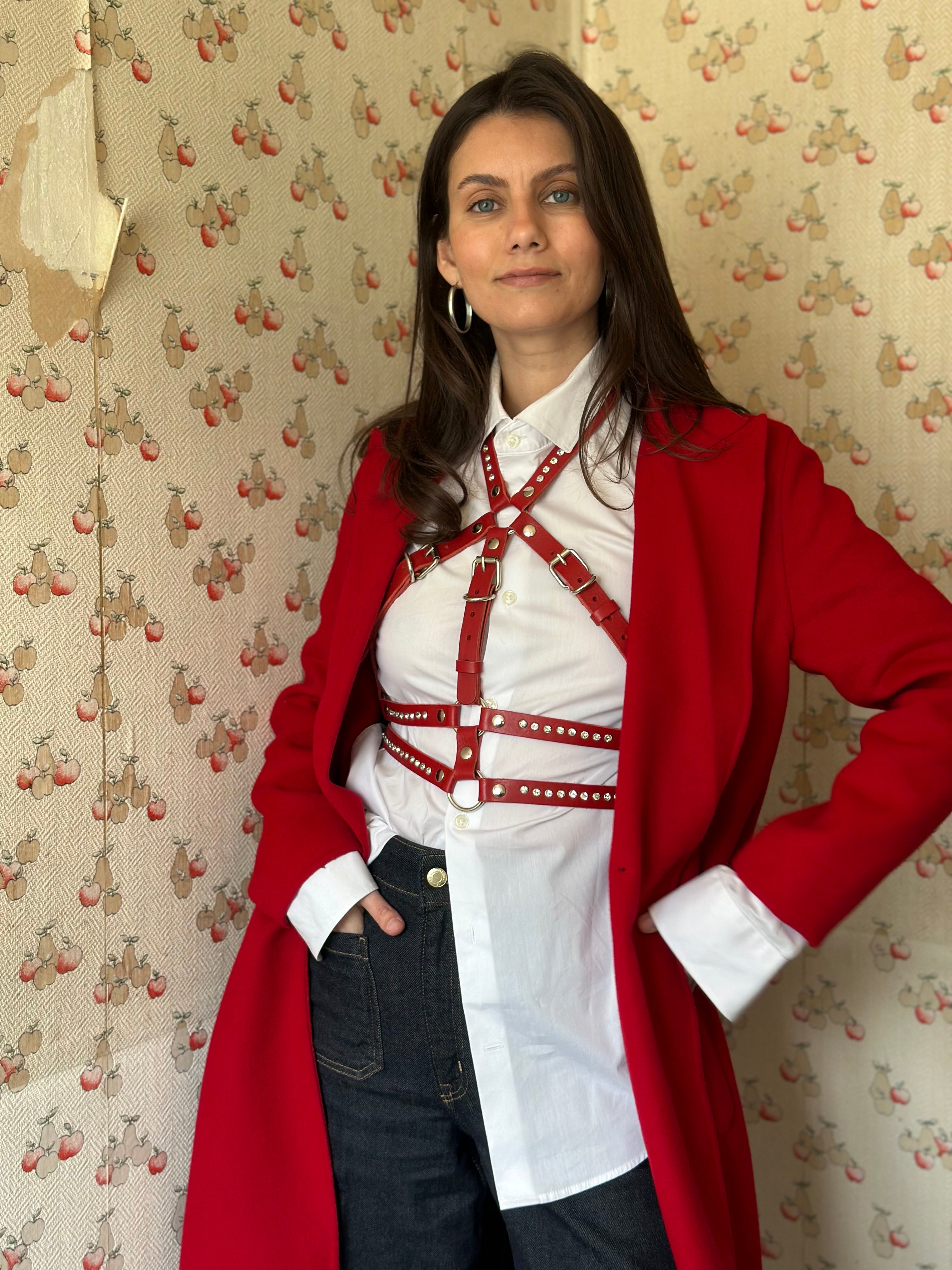 RedTulip Leder Accessoire in Rot mit weißem Strass veredelt, über weißer Bluse zur Jeans und rotem Mantel, Ganzkörperaufnahme – XMORENIUM-NERO
