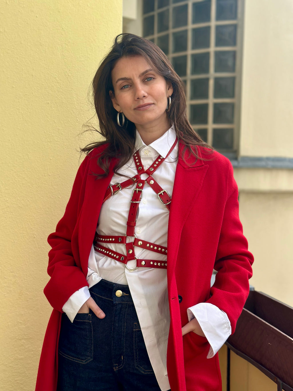 RedTulip Leder Accessoire in Rot mit weißem Strass verziert, über weißer Bluse zur Jeans und rotem Mantel, Ganzkörperaufnahme – XMORENIUM-NERO