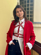 RedTulip Leder Accessoire in Rot mit weißem Strass verziert, über weißer Bluse zur Jeans und rotem Mantel, Ganzkörperaufnahme – XMORENIUM-NERO