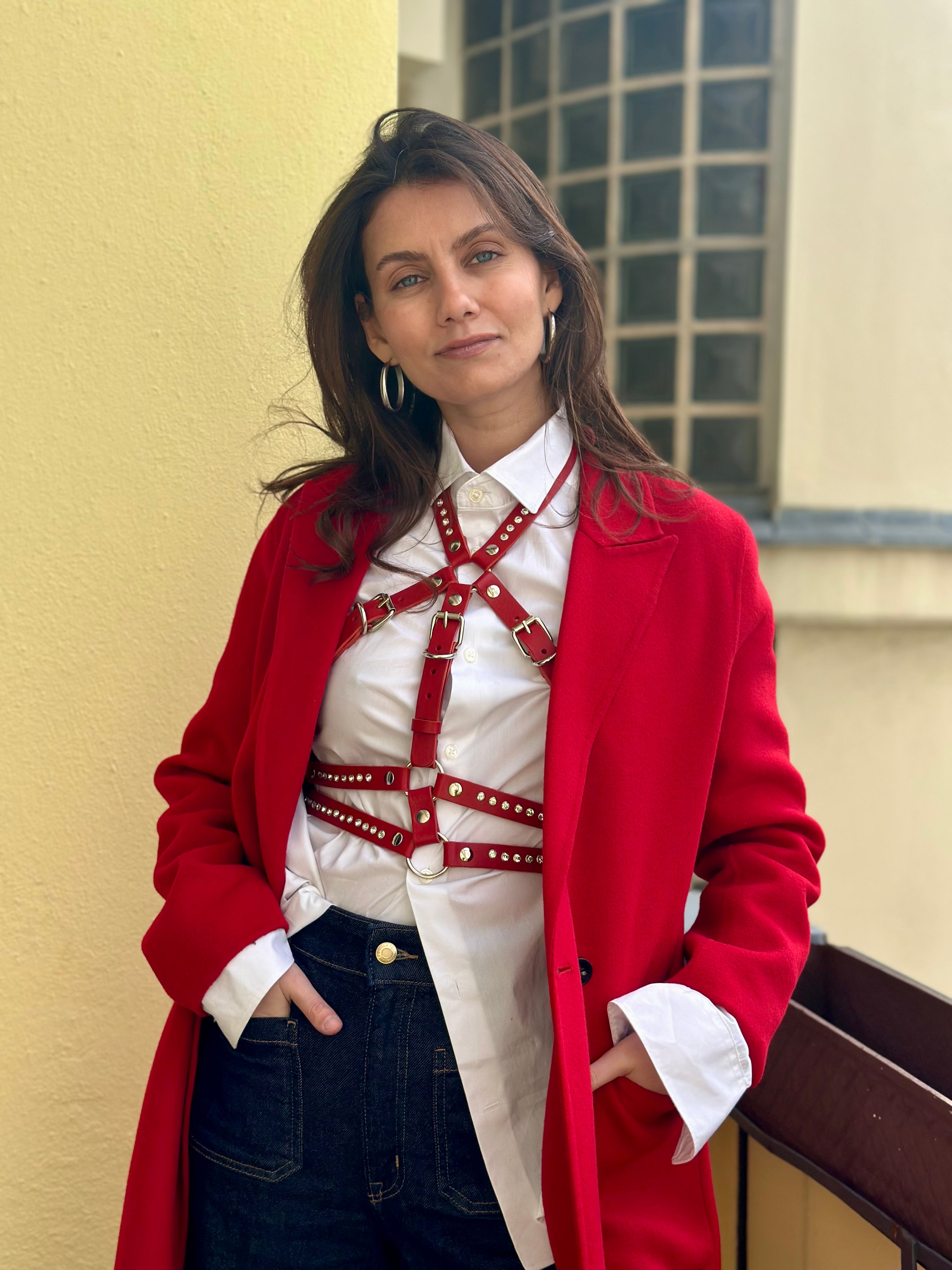 RedTulip Leder Accessoire in Rot mit weißem Strass verziert, über weißer Bluse zur Jeans und rotem Mantel, Ganzkörperaufnahme – XMORENIUM-NERO