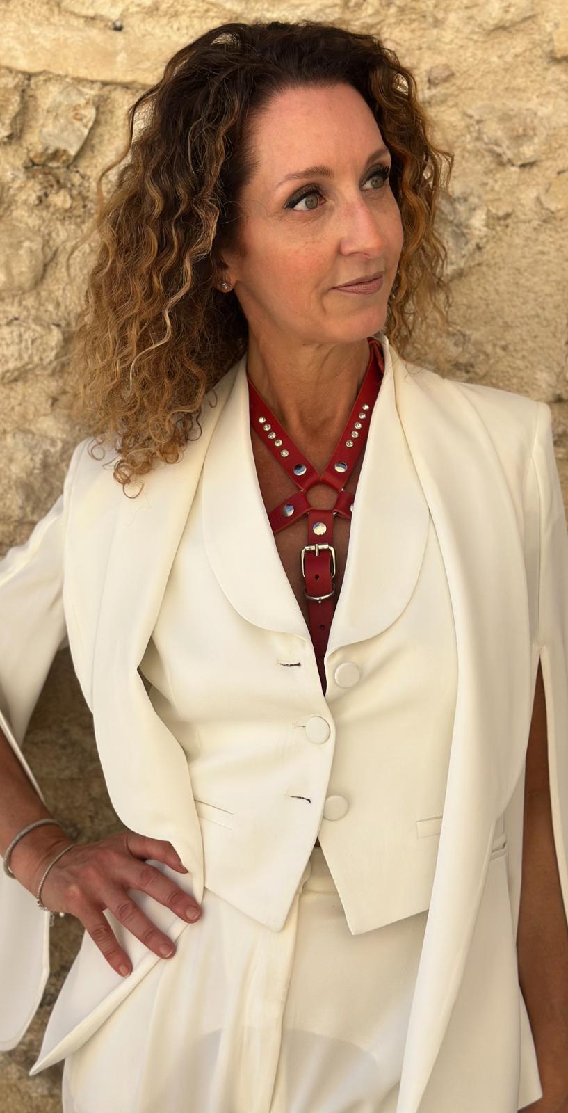 Elegante Dame trägt RedTulip WhiteDiamant Lederaccessoire aus rotem italienischem Leder zu weißem Blazer – XMORENIUM-NERO